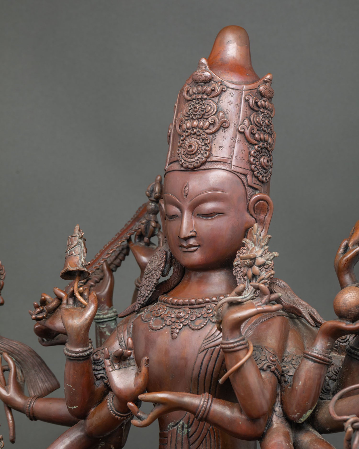 Side close-up of 18-armed Chundi statue showing hand-cast copper details and mudras