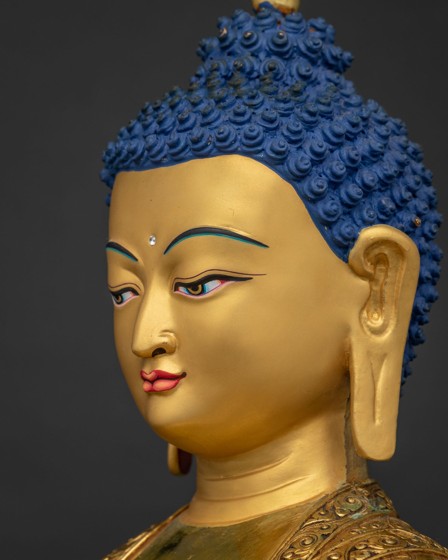 Side close up of Amitabha Buddha's gold-painted face and ear detail