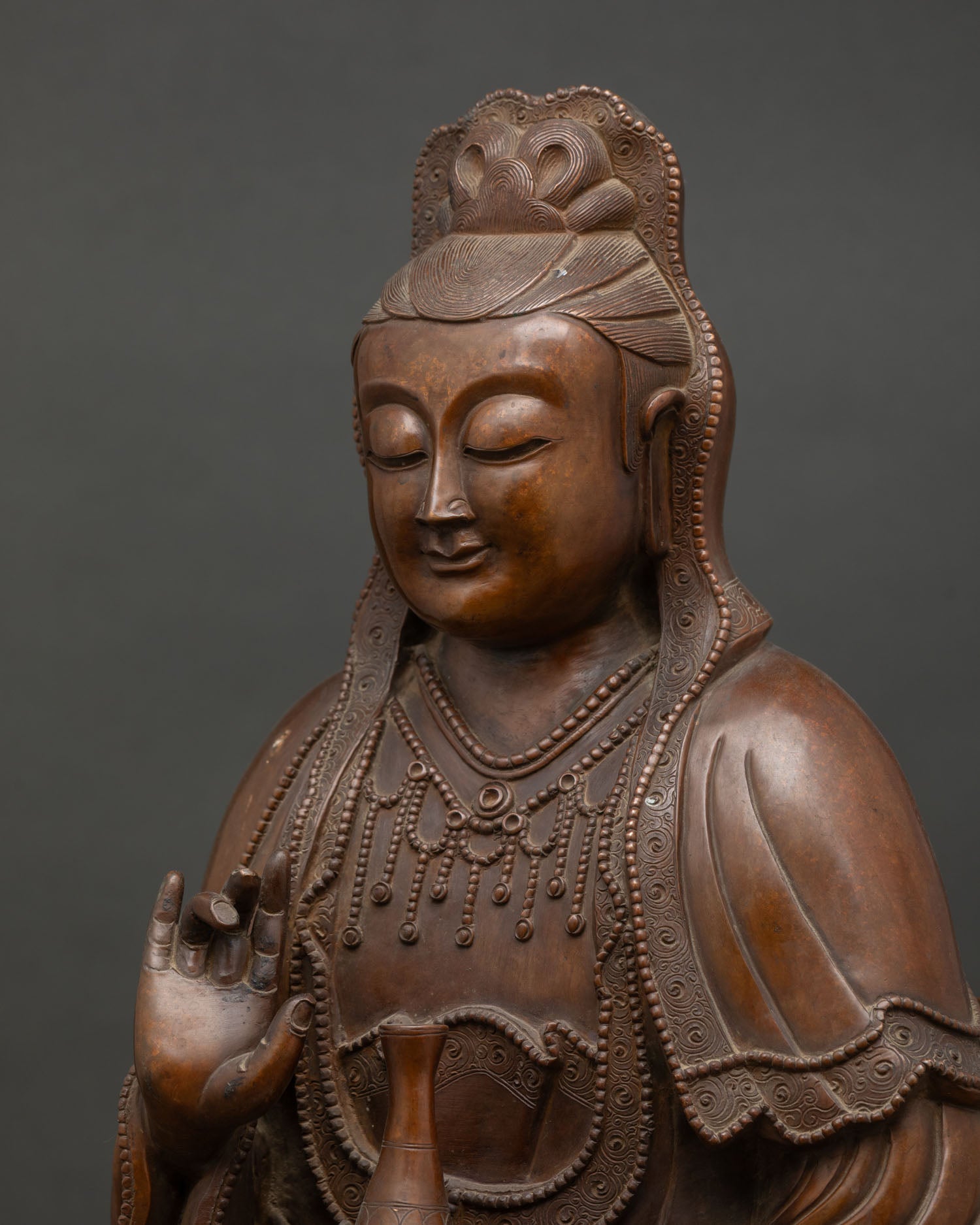 Side close-up of Guanyin serene face and crown, hand-cast oxidized copper Buddhist sculpture