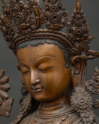 Side close-up of Green Tara statue face and ornate crown details