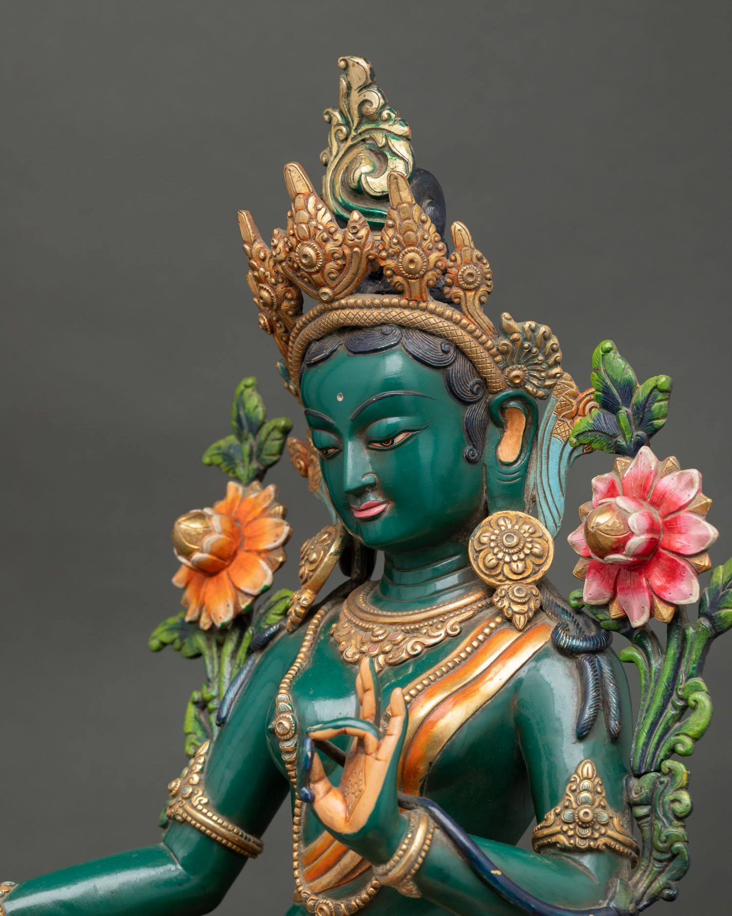 Side close up of Green Tara statue highlighting ornaments, lotus throne and copper craftsmanship