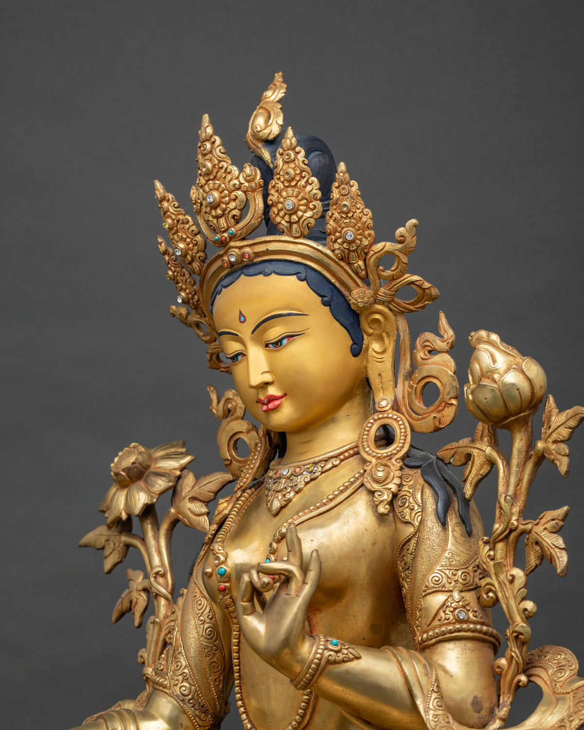 Side close-up of Green Tara Statue – lotus mudra hand and ornate jewelry detail