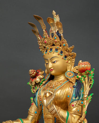Side close-up of Green Tara statue showing lotus flower stem, painted robes, and gold detailing