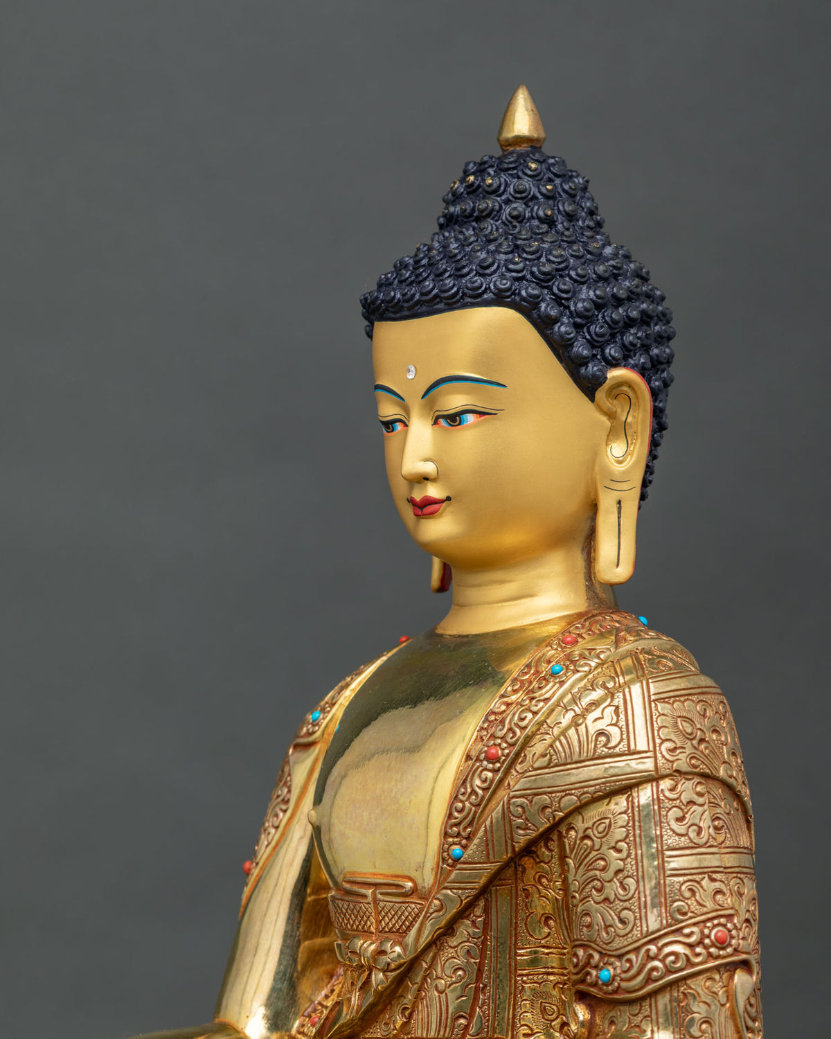 Side close up of handcrafted Shakyamuni Buddha sculpture highlighting intricate floral robe.
