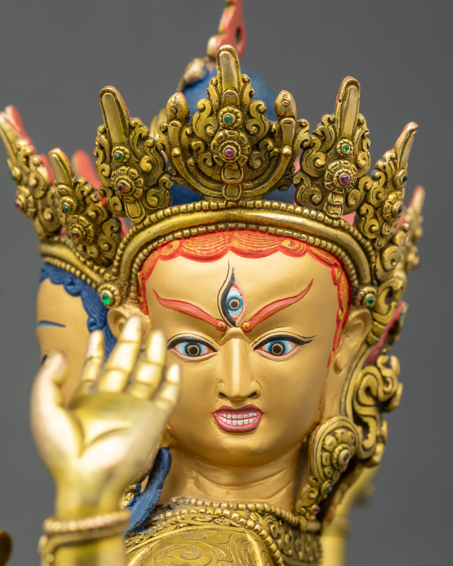 Side close-up of Namgyalma statue, copper and gold with sacred hand gestures