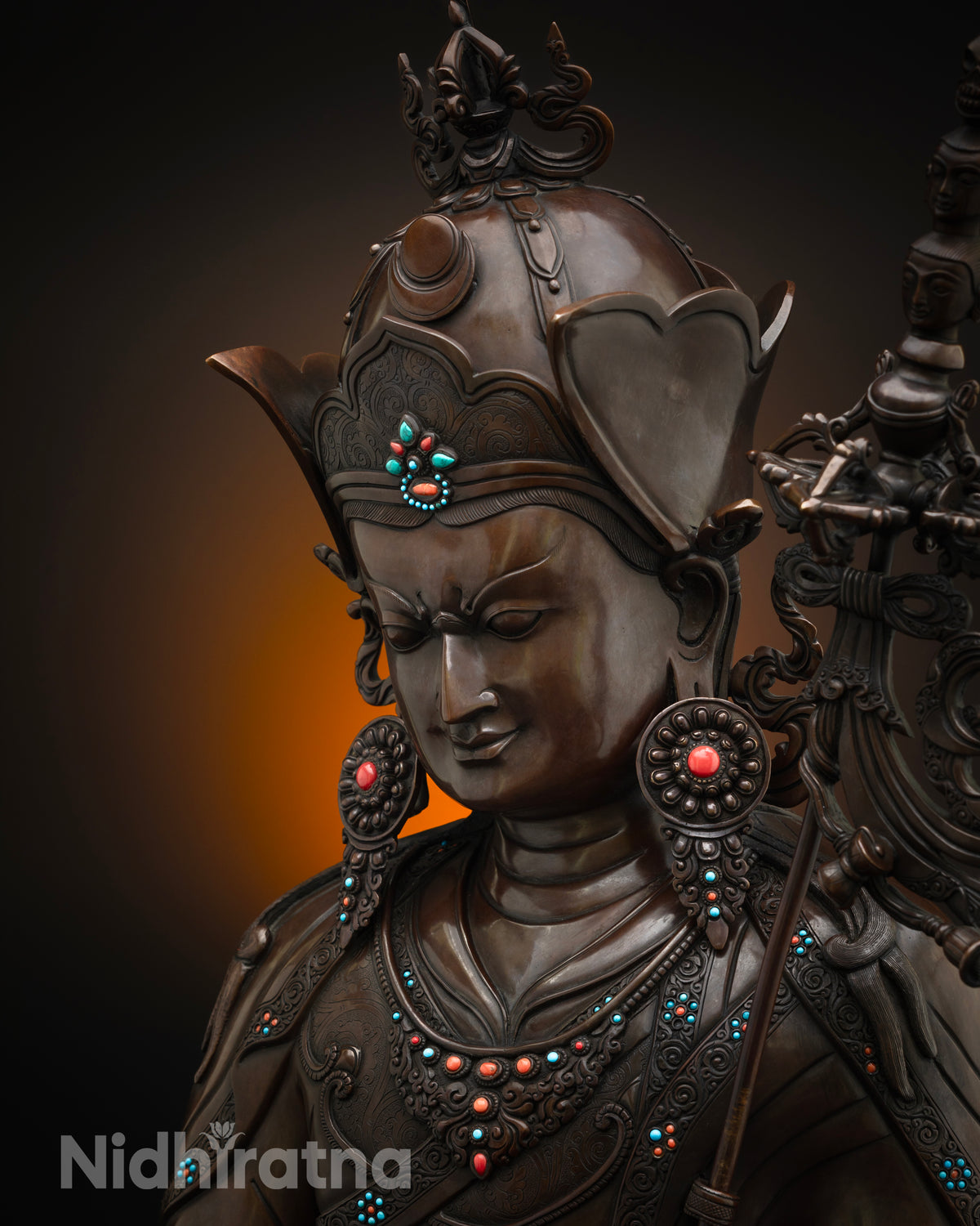 Side close up of oxidized copper Guru Rinpoche statue showing khatvanga staff