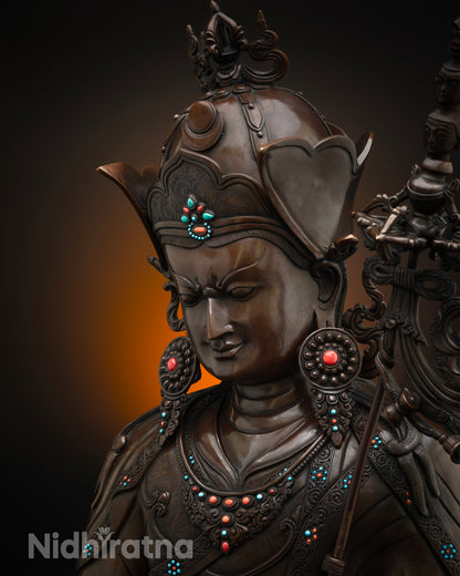 Side close up of oxidized copper Guru Rinpoche statue showing khatvanga staff