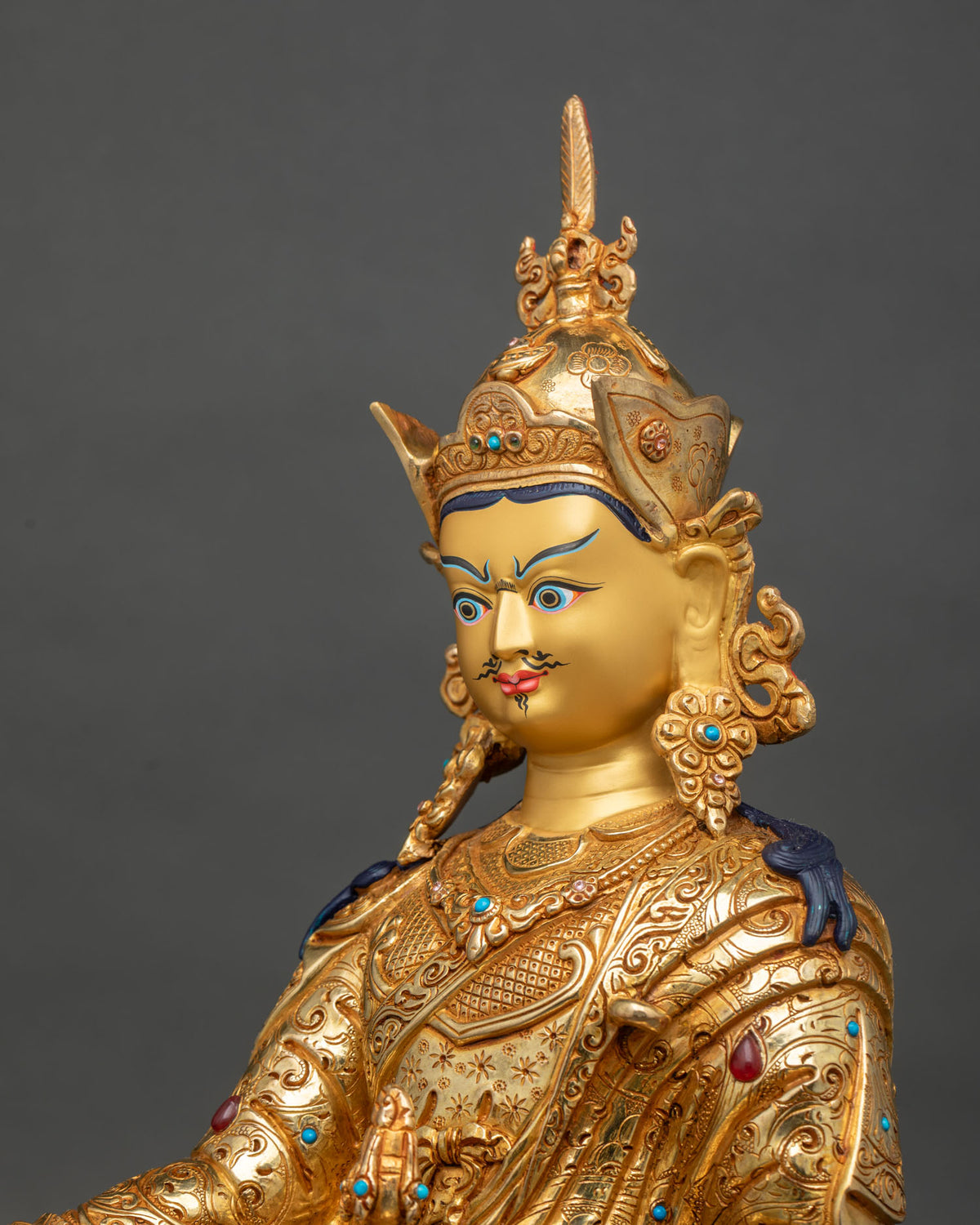 Side close up of Padmasambhava statue showing hand-chased robe and lotus pedestal