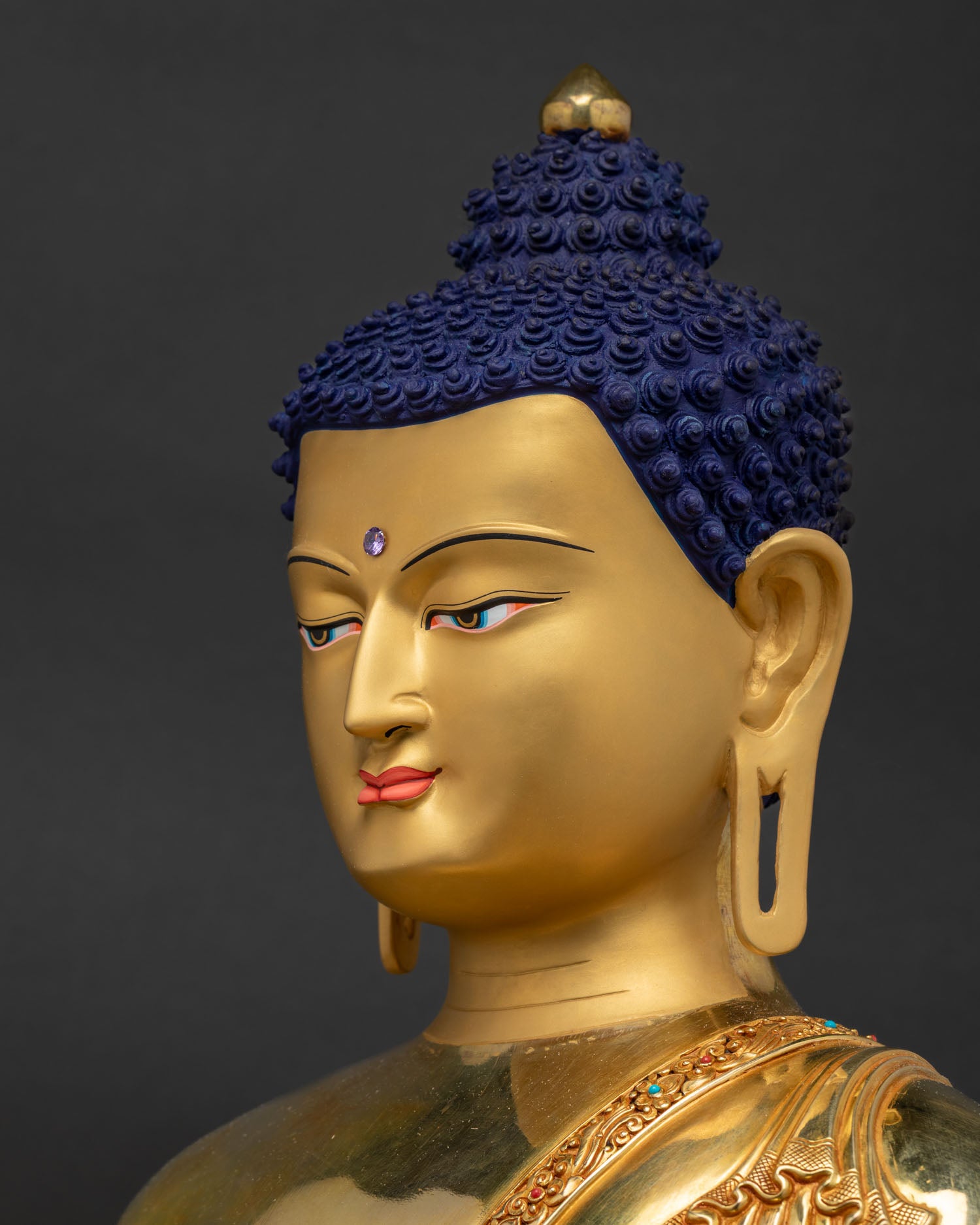 Side close-up of Shakyamuni Buddha face showing fine gold-gilded detailing