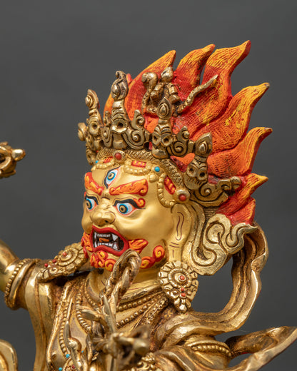 Side close up of Vajrapani statue highlighting arm movement, vajra and flame backdrop
