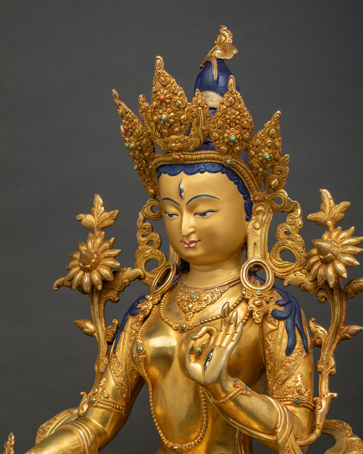 Side close-up of White Tara statue showing crown and lotus flower detail