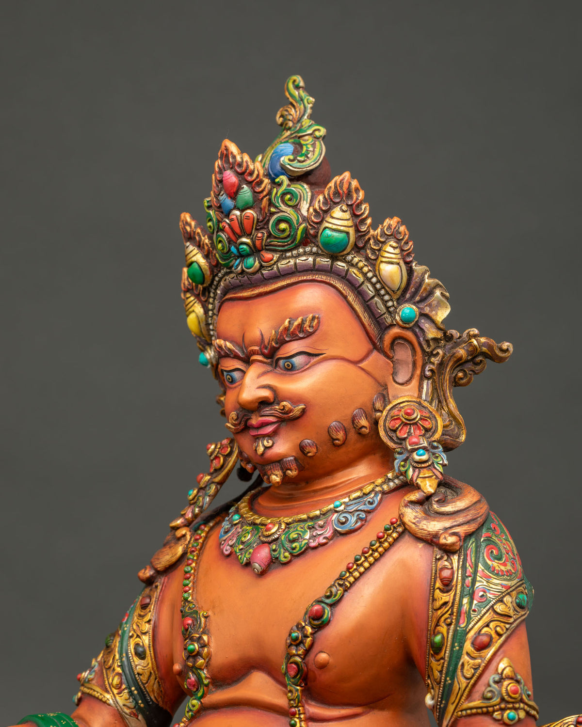 Side close up of Yellow Dzambhala statue with jewelry, ornate crown and hand-painted copper details