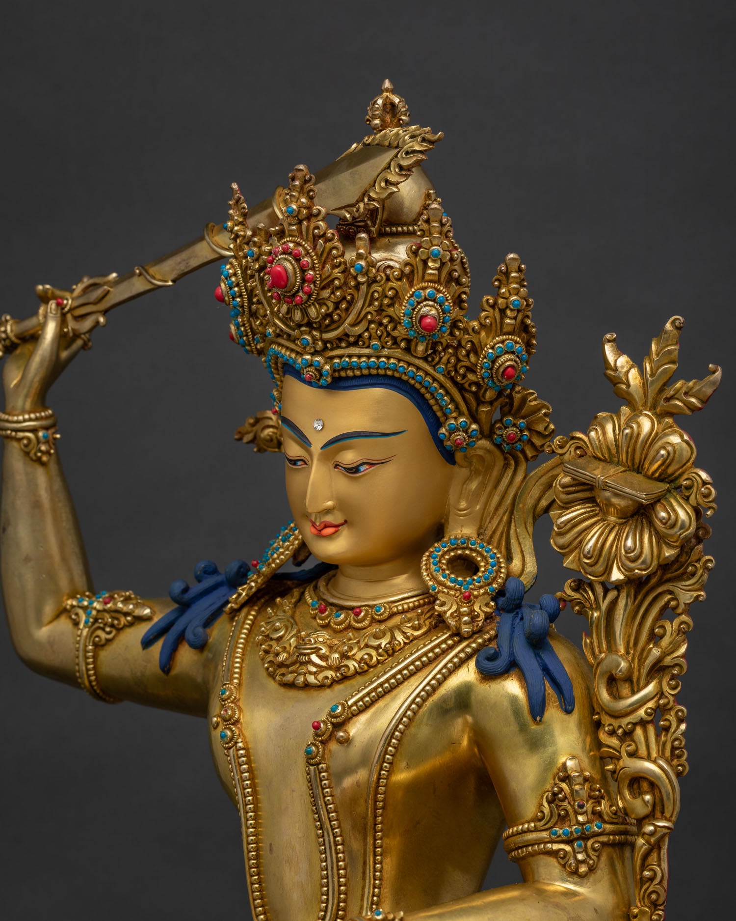 Side detail of Manjushri statue, gilded shoulder and turquoise-inlaid crown