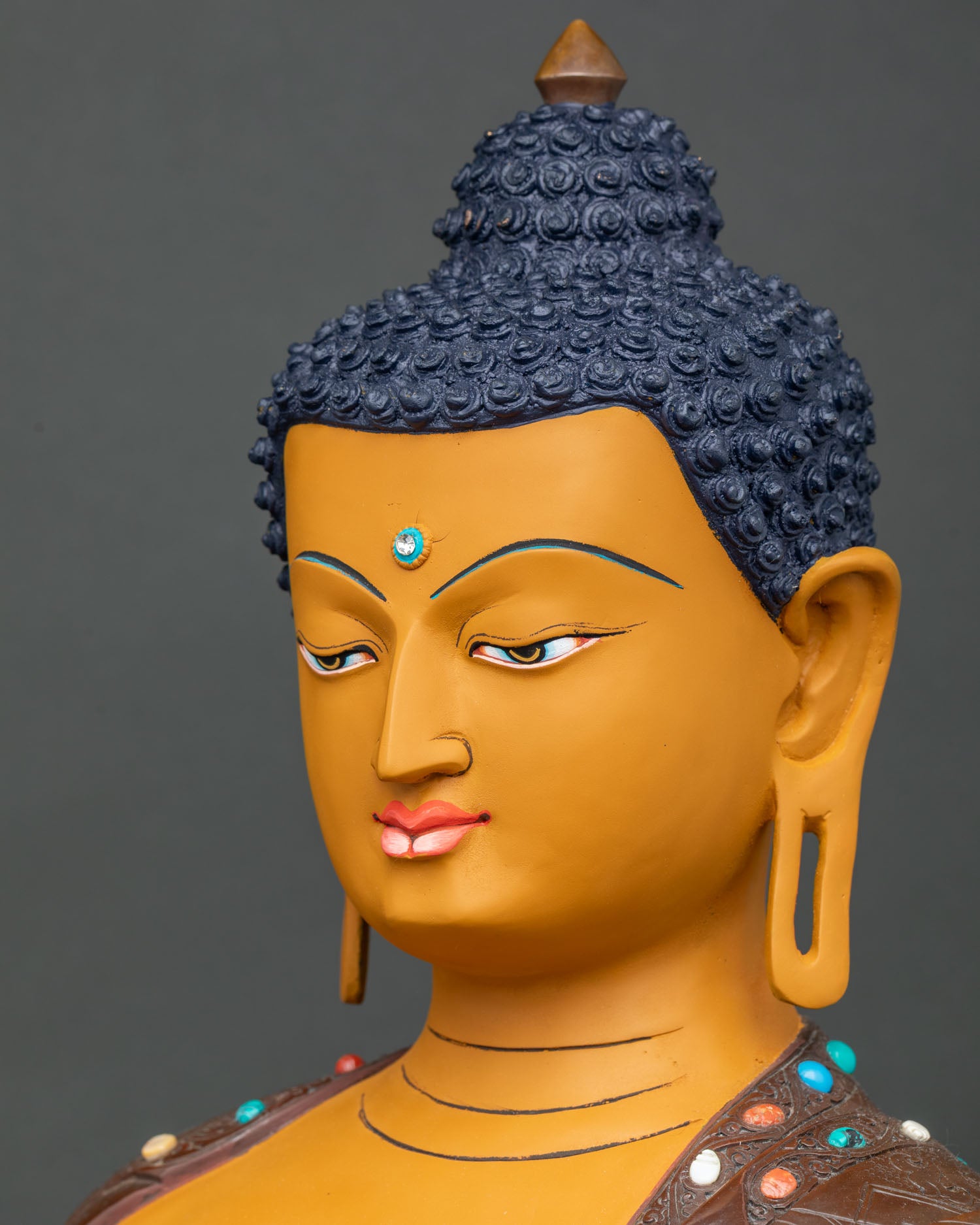 Side face close-up of Shakyamuni Buddha statue with curled hair and peaceful expression