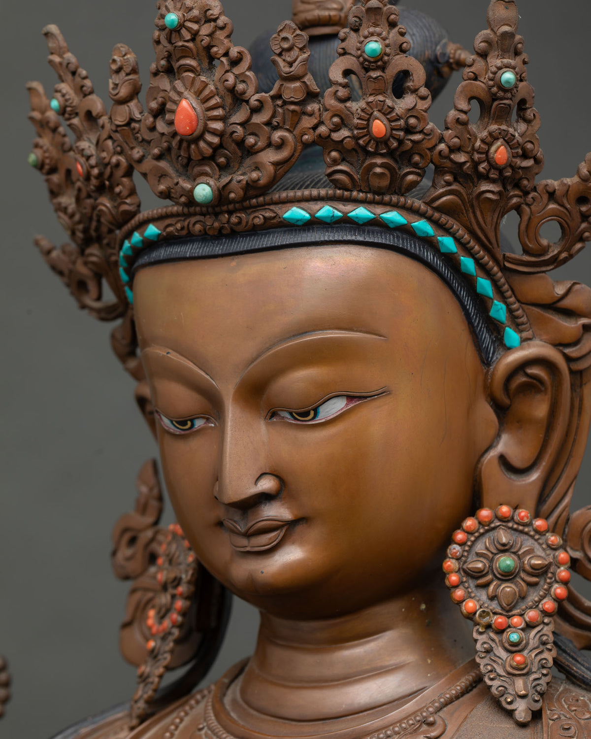 Side profile close-up of Chenrezig's face showing serene expression and crown detail