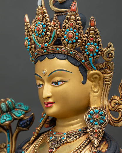 Side profile close up of Green Tara statue face with gold-painted features and ornate jeweled crown