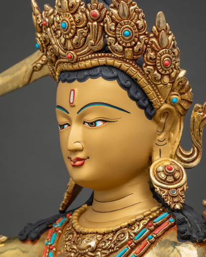 Side profile close-up of Maha Manjushri statue face with hand-painted eyes and gold jeweled crown