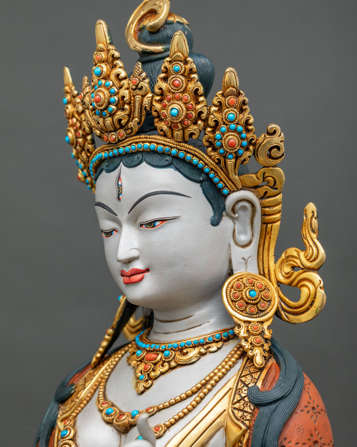 Side profile close-up of Sitatapatra statue face with jeweled headdress and halo, handcrafted in Nepal