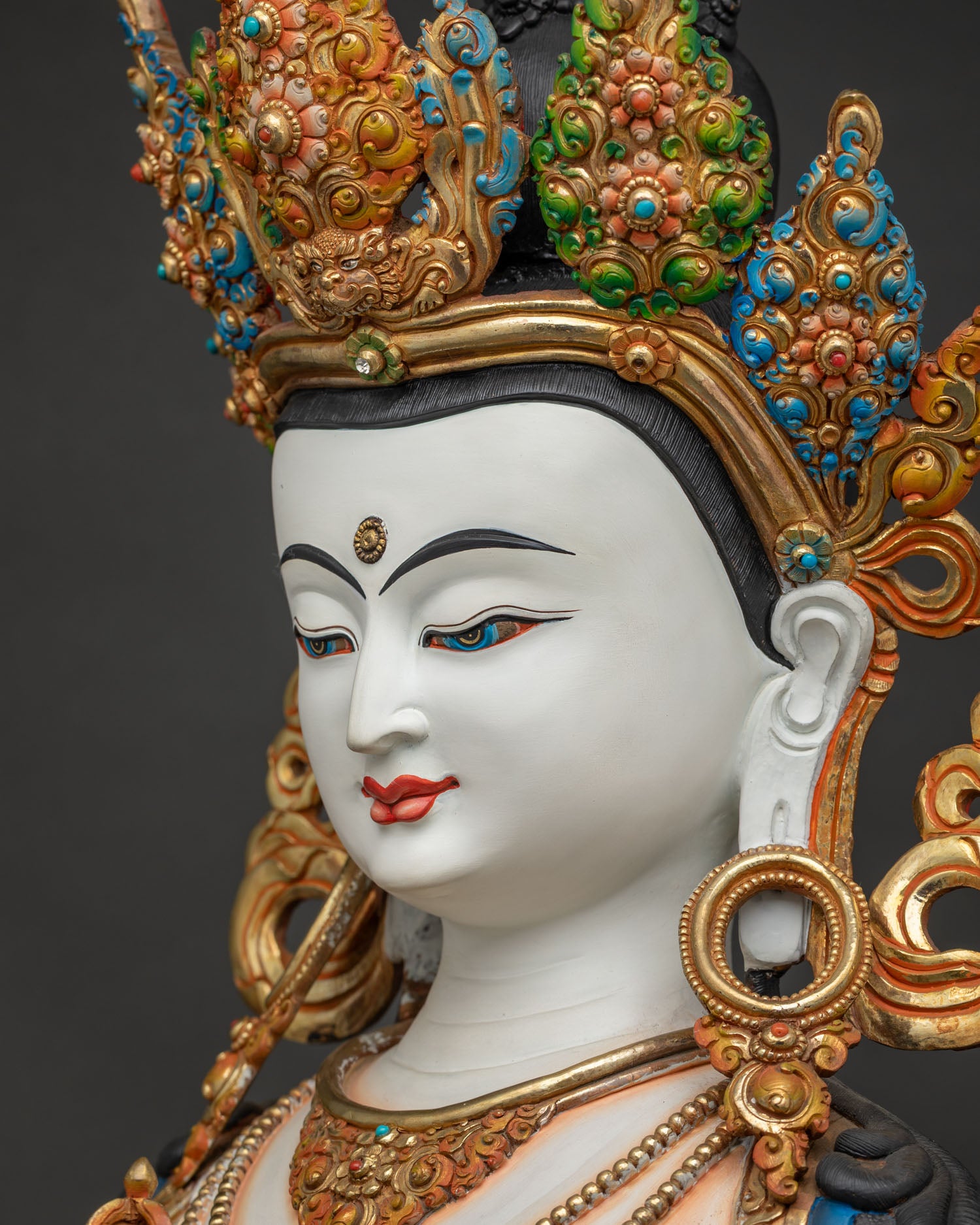 Side profile close-up of Vajrasattva statue's face, gold-gilded Buddha sculpture