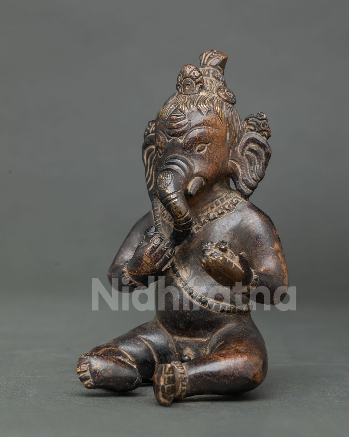 Side profile of antique Ganesha Buddhist statue with long ears and sweets, handmade in Nepal
