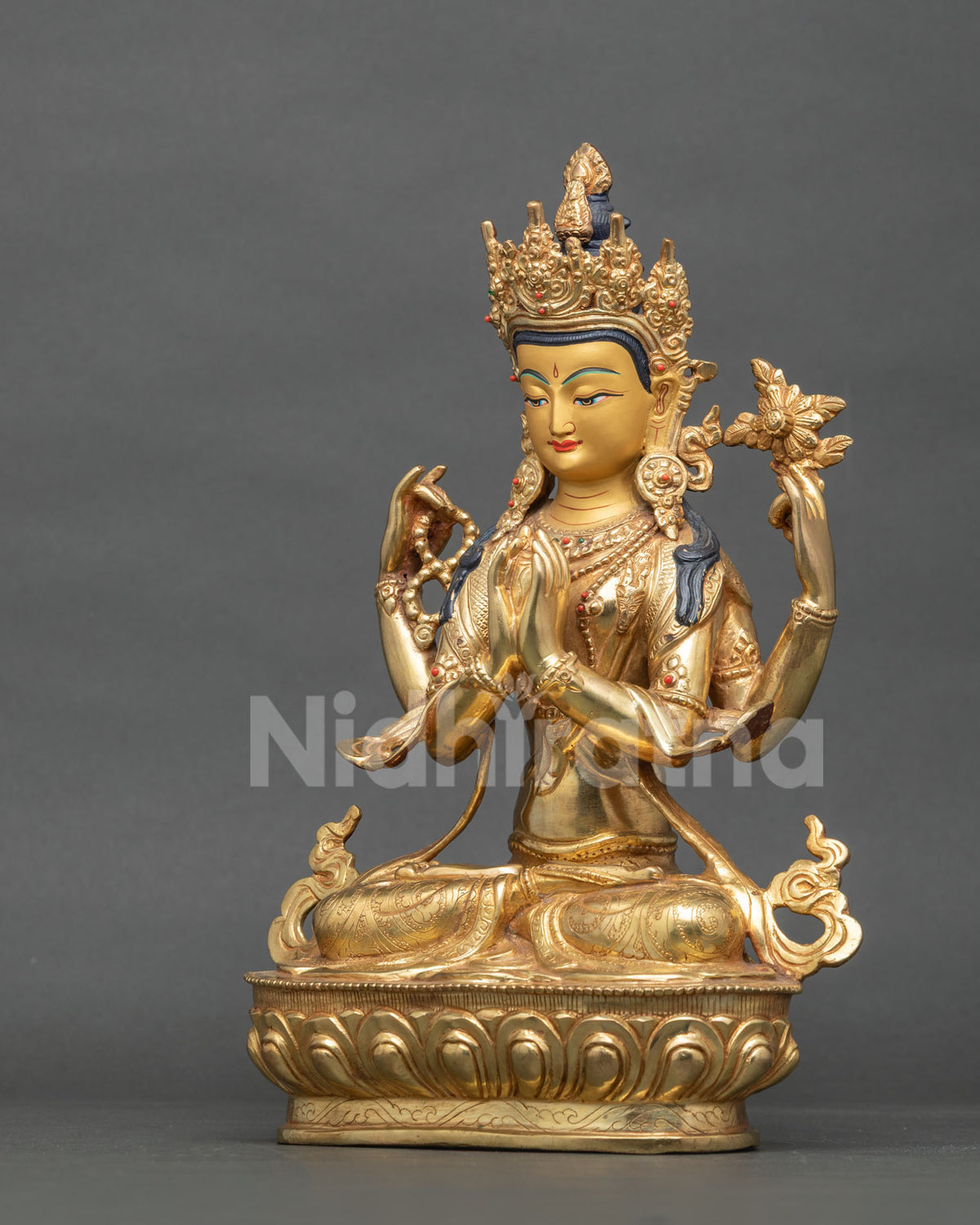 Side profile of four-armed Avalokiteshvara statue with ornate lotus base