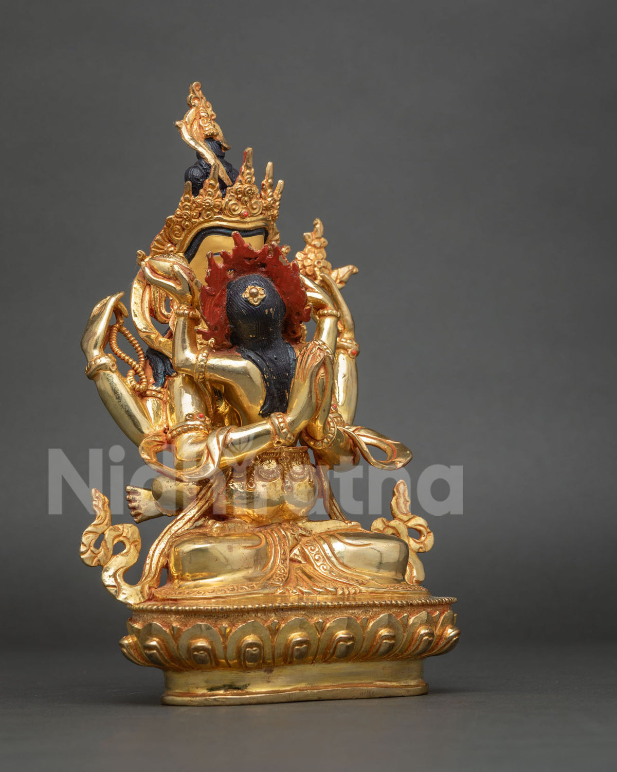 Side profile of Four-Armed Chenrezig Yab-Yum statue showing arms and lotus base