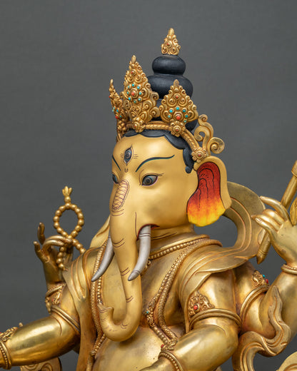 Side profile of Ganesh with silver tusks, curled trunk and ornate gold crown, Nepali copper statue