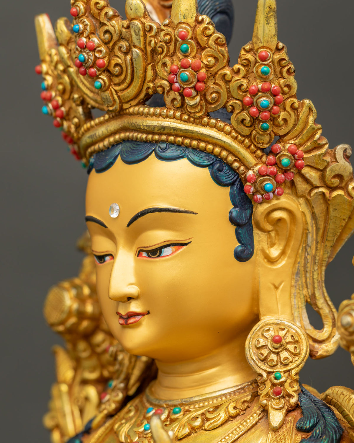 Side profile of Green Tara statue face with serene expression and 24K gold painted details