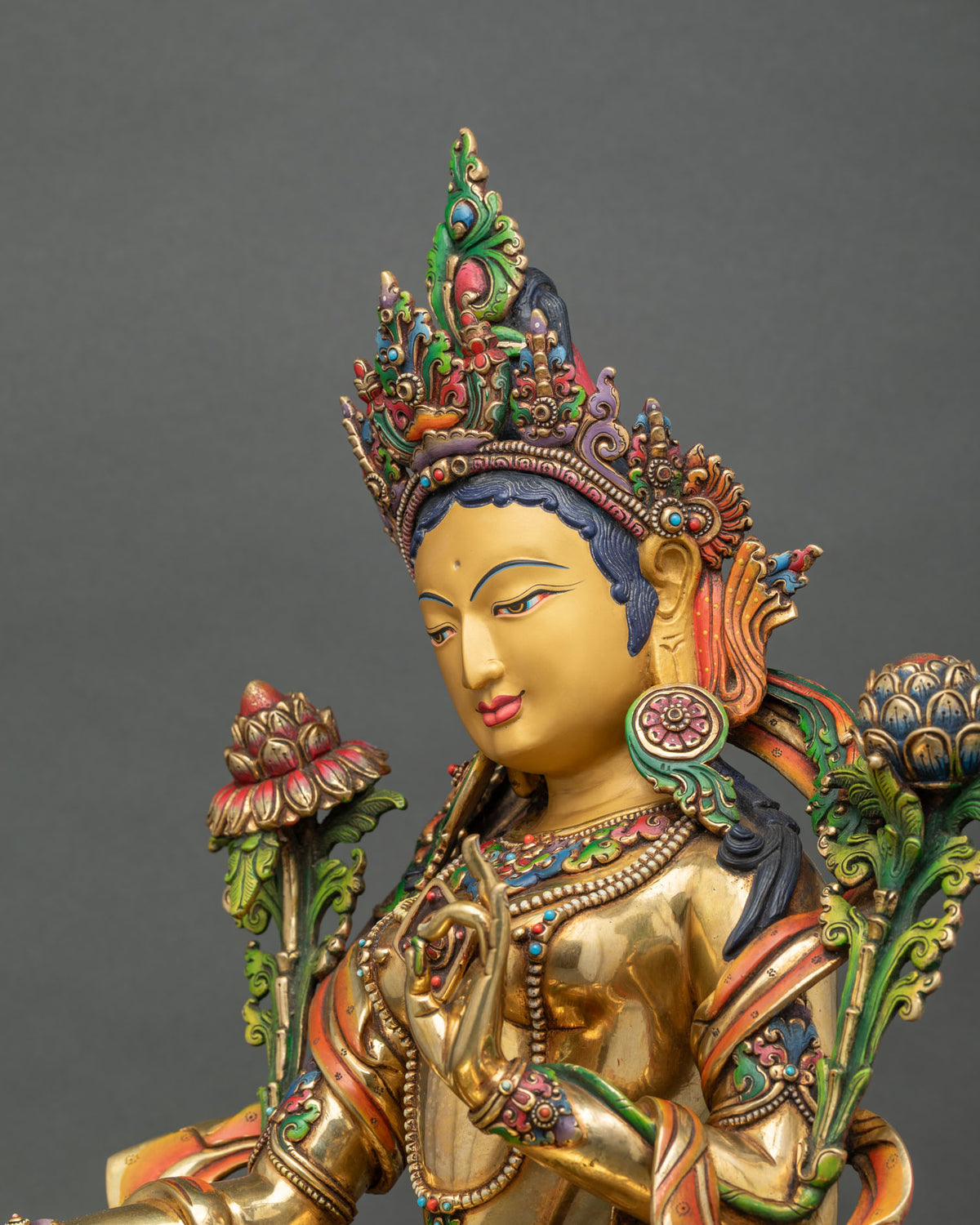 Side profile of handcrafted Nepali Green Tara statue with gentle smile, ornate crown and acrylic accents