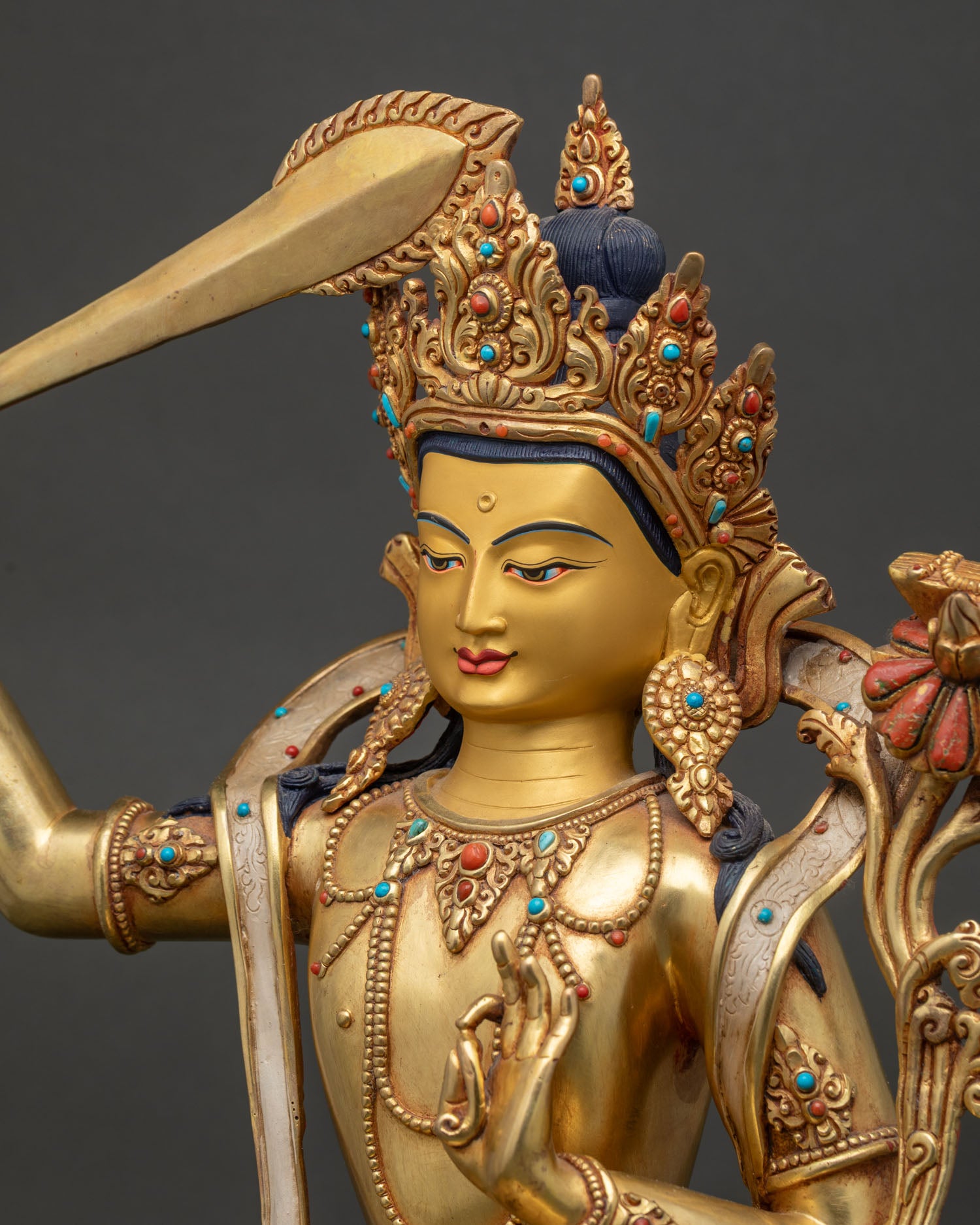 Side profile of Manjushri Statue with gold painted face and jeweled crown