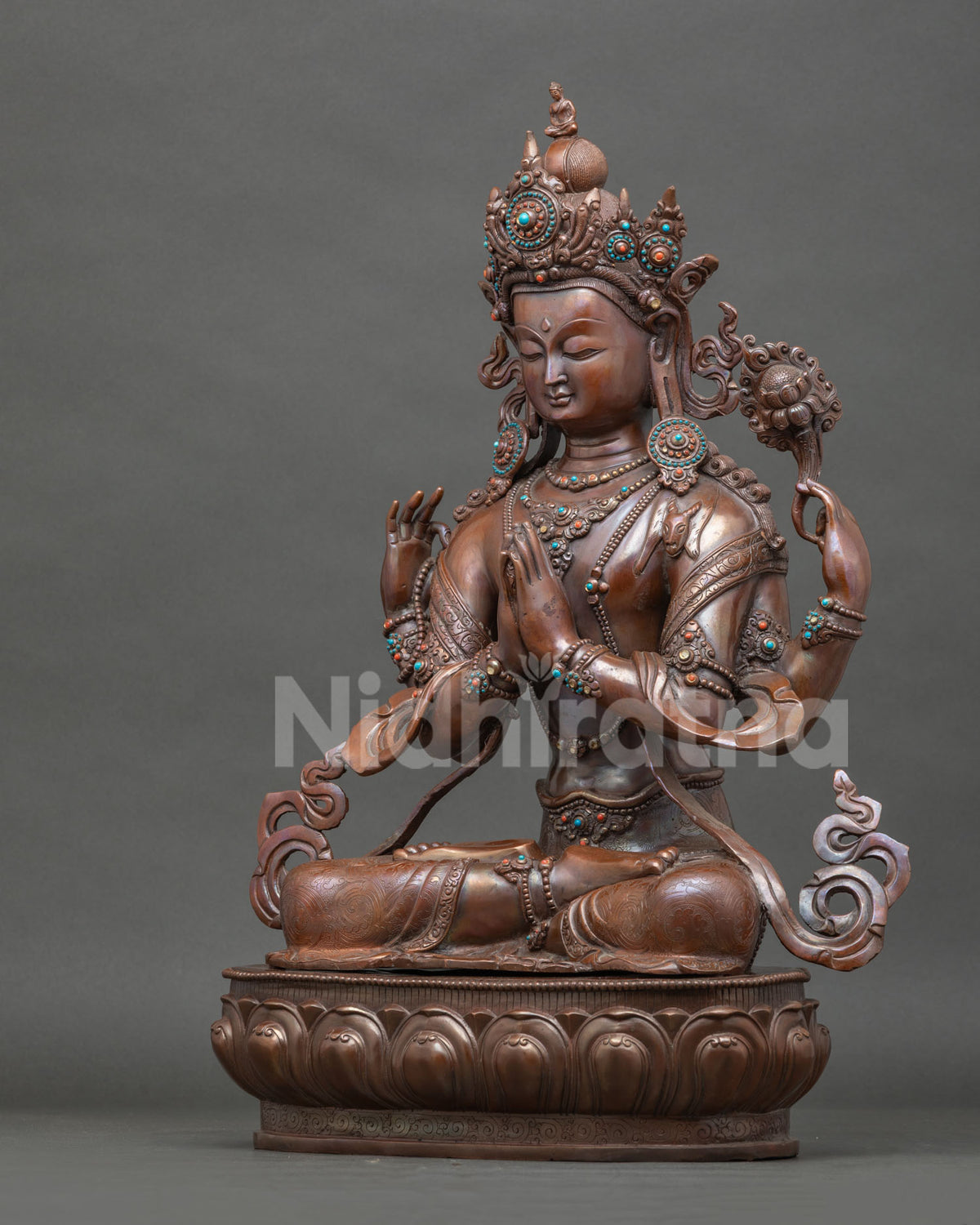 Side view Chenrezig statue with floral motif garment lotus pedestal and oxidized patina.