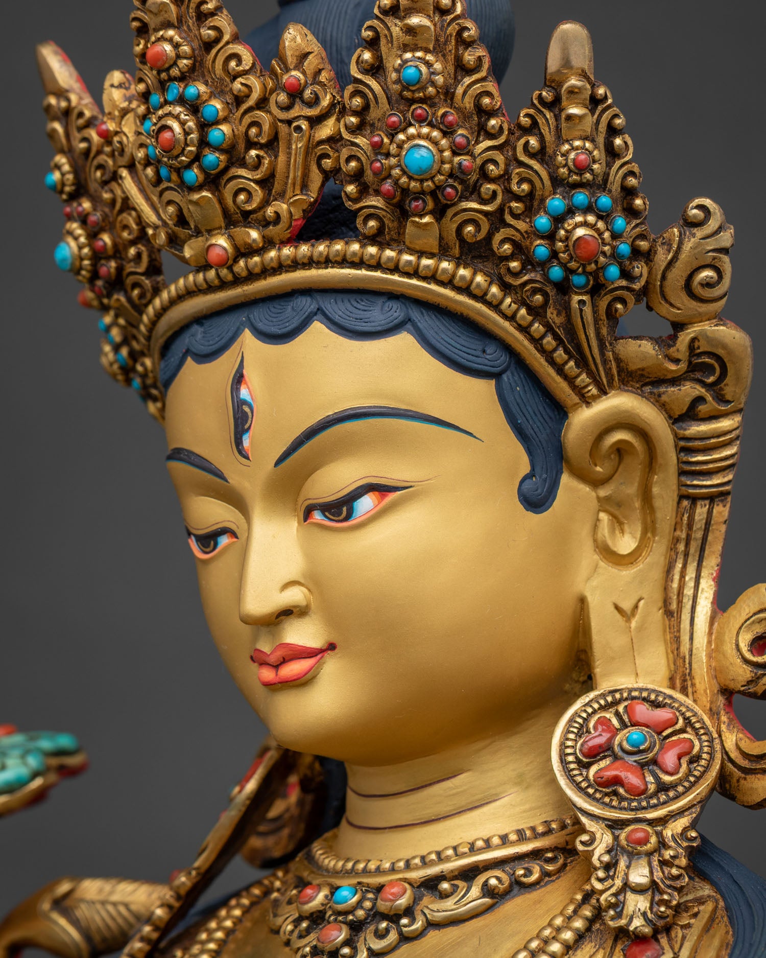 Side view close-up of White Tara statue's face and five-jeweled crown