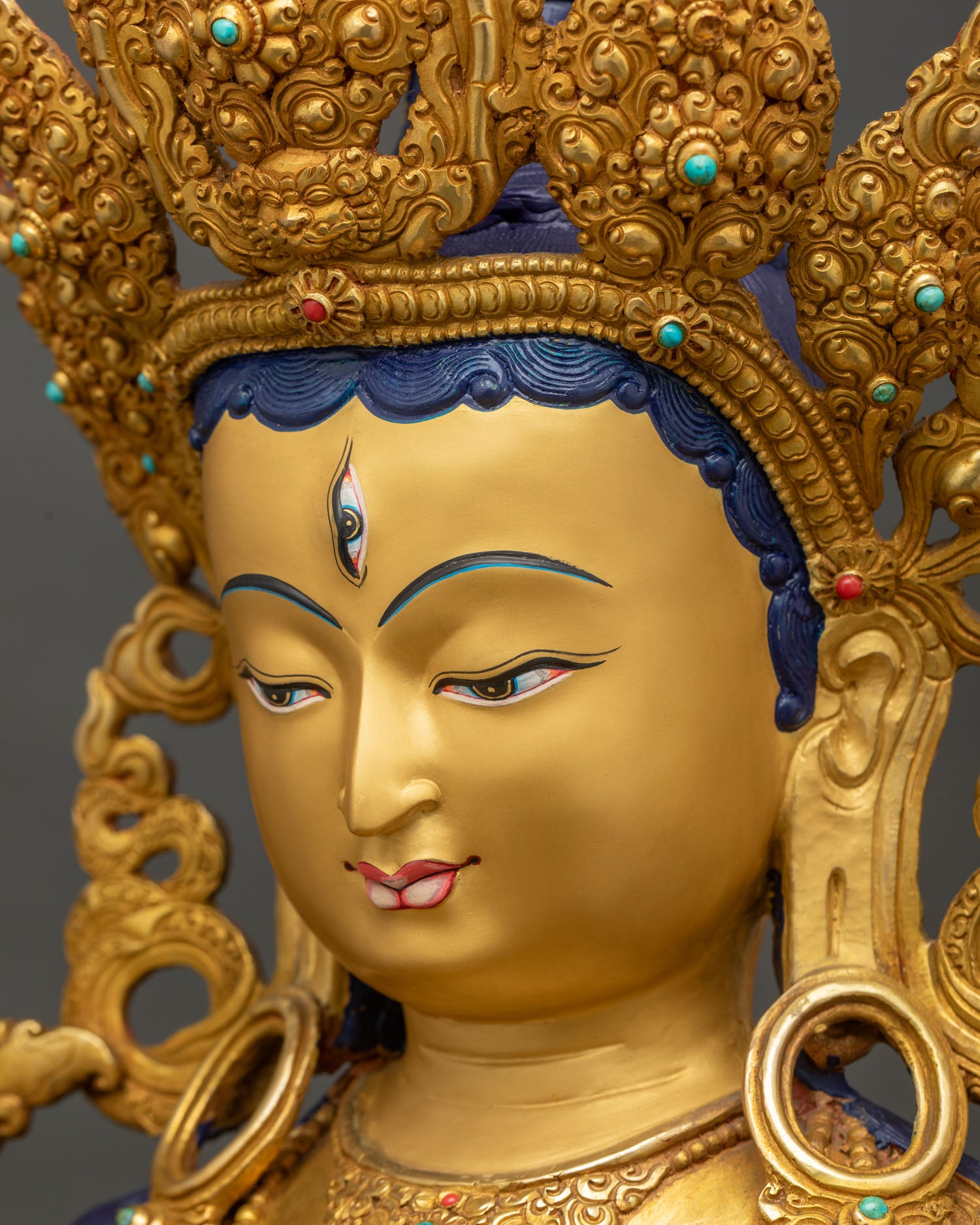 Side view close-up of White Tara statue's face and gemstone-inlaid crown