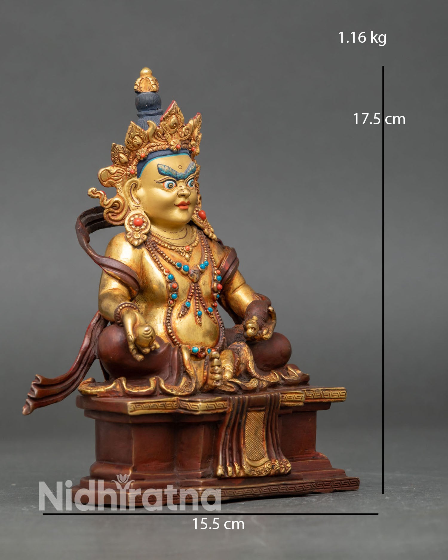 Side view of Dzambhala statue, seated on lotus throne royal ease pose holding citrons and jewels mongoose spouting treasures Buddhist wealth symbol