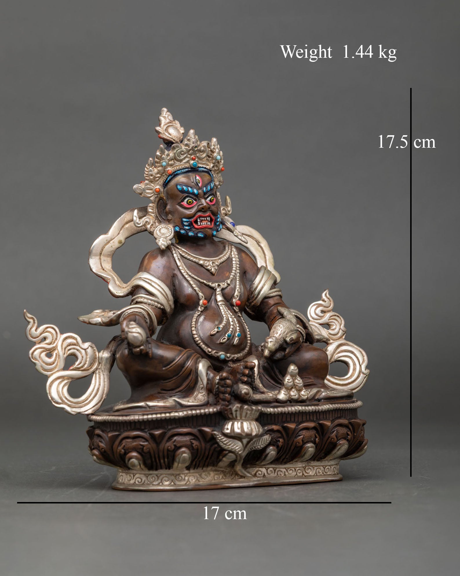 Side view of the Dzambhala statue in traditional seated posture, made of copper.