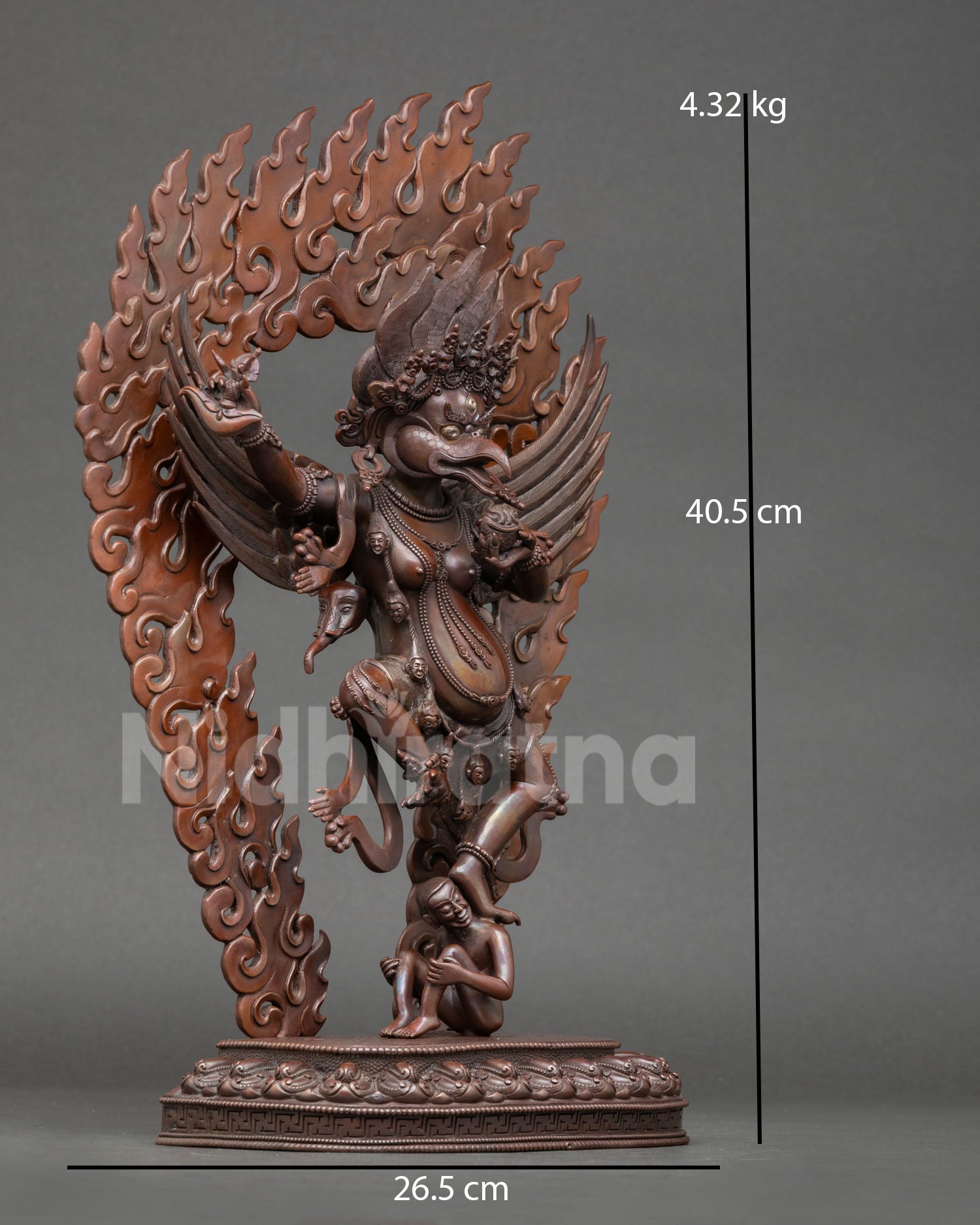 Side view of Garuda statue standing over subdued figure symbolic victory over negativity Nepalese metal art sculpture