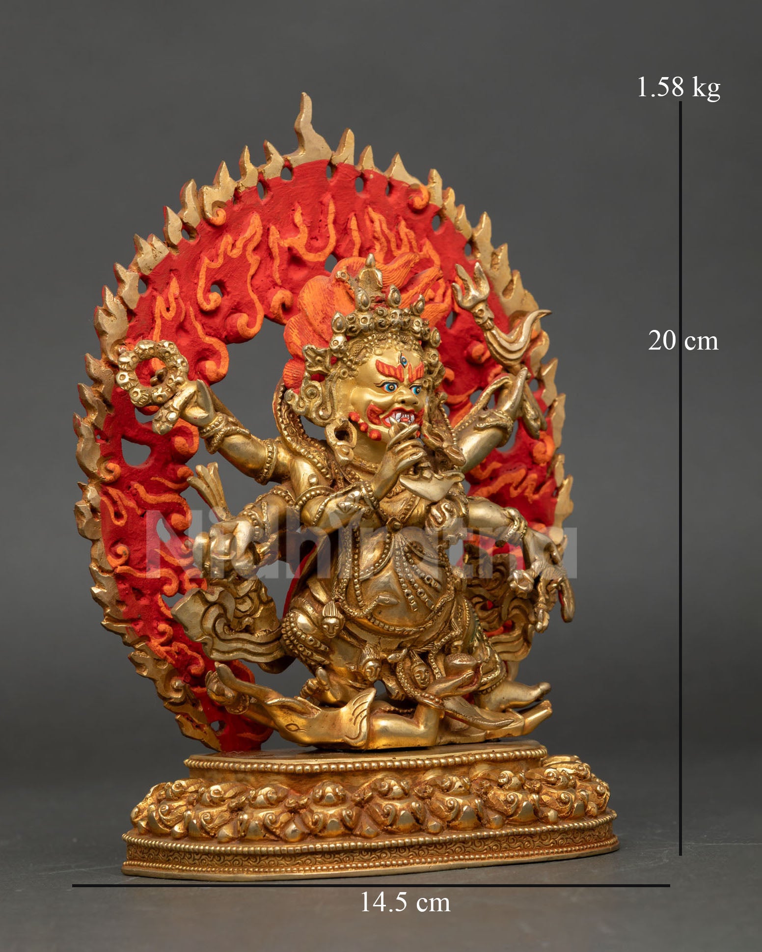 Side view of handcrafted Six Armed Mahakala sculpture with tiger skin robes multiple ritual implements and radiant halo of wisdom flames