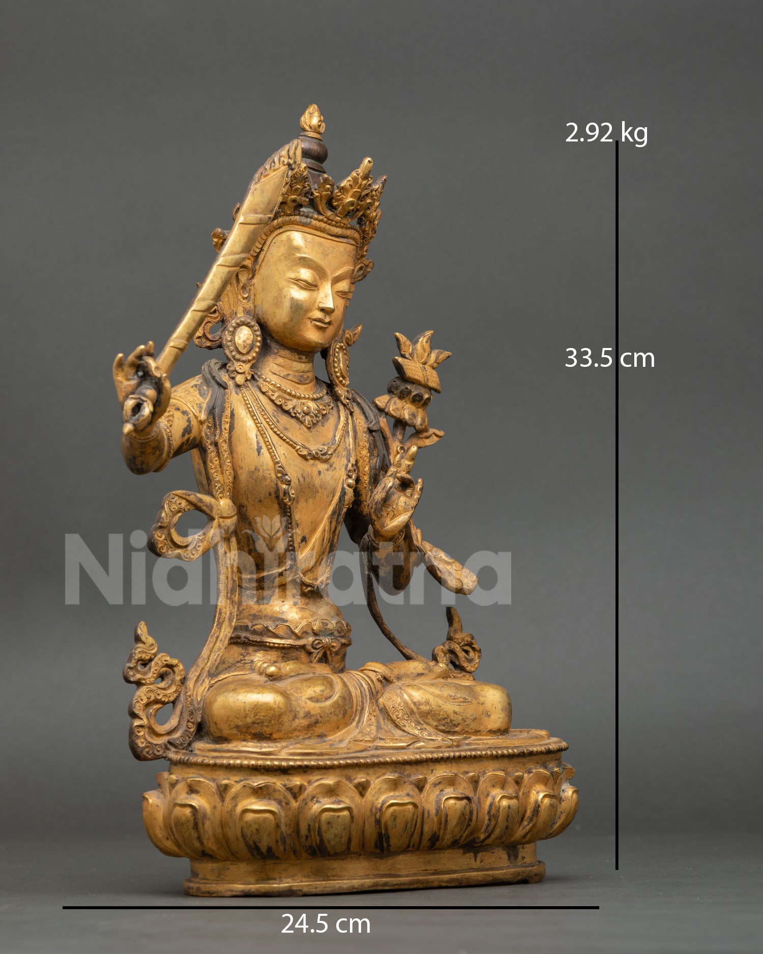 Side view of Manjushri statue holding utpala flower in abhaya mudra, double-edged wisdom sword flame, crown, antique copper Buddhist meditation art, Nepal
