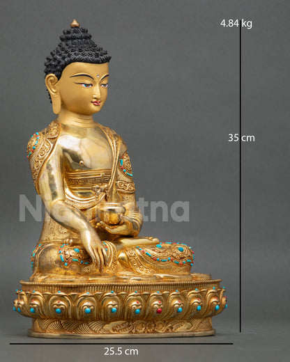 Side view of Nepalese Buddha statue holding begging bowl with floral carved monastic robe traditional copper gold gilded Buddhist sculpture