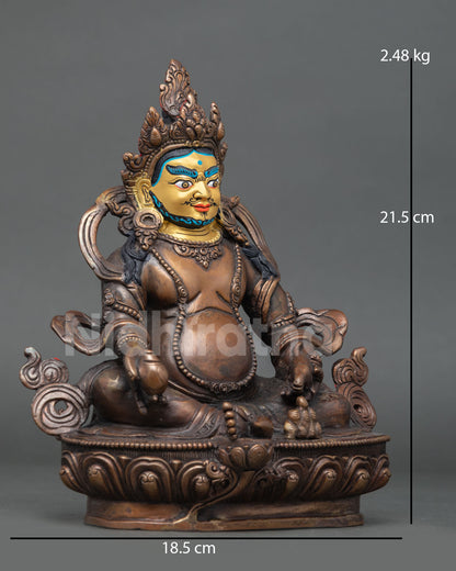 Side view of a Nepalese Dzambhala statue seated on a lotus pedestal with a conch shell resting on a lotus flower.