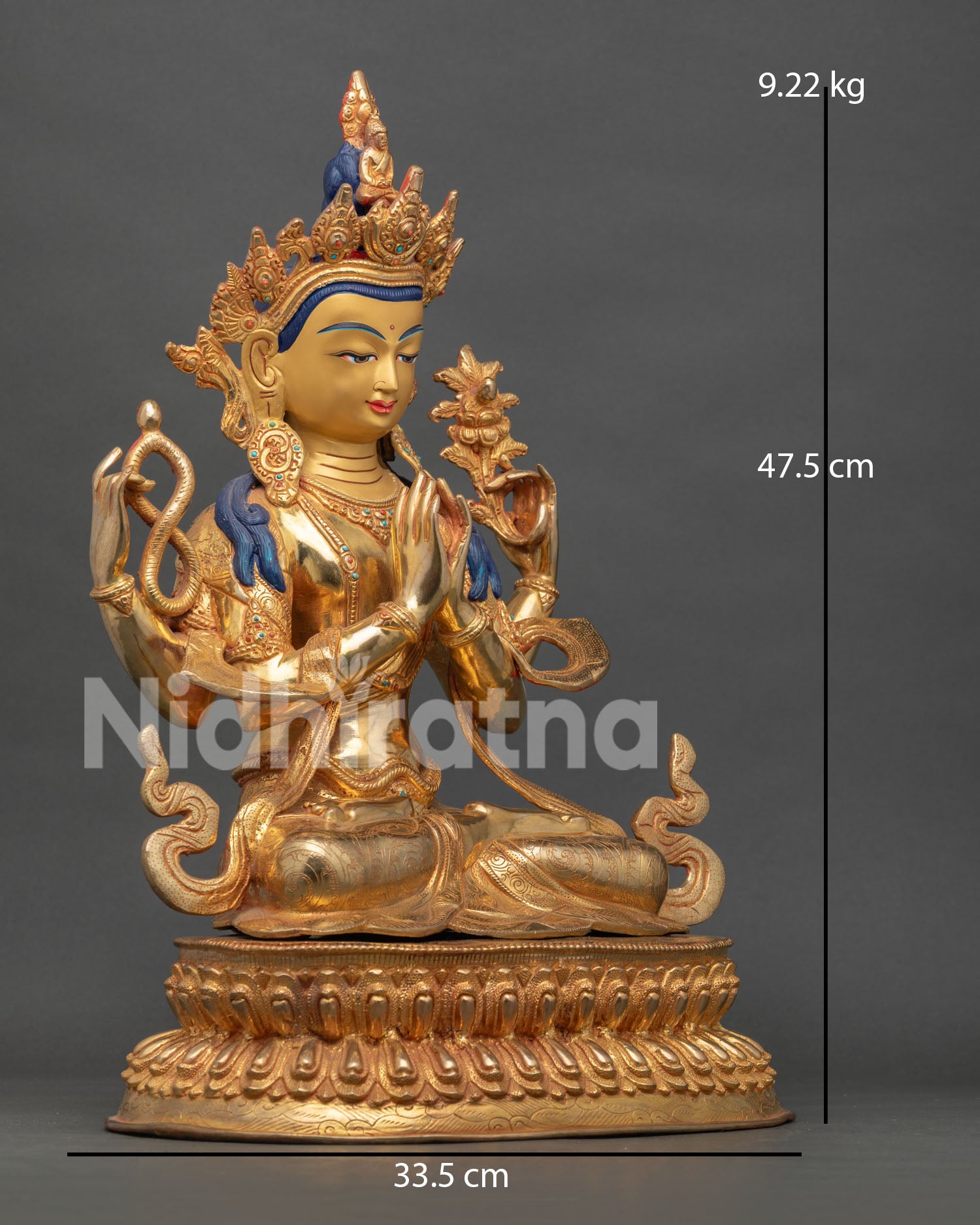 Side view of Buddhist Chenrezig sculpture seated on double lotus pedestal holding mala and lotus flower