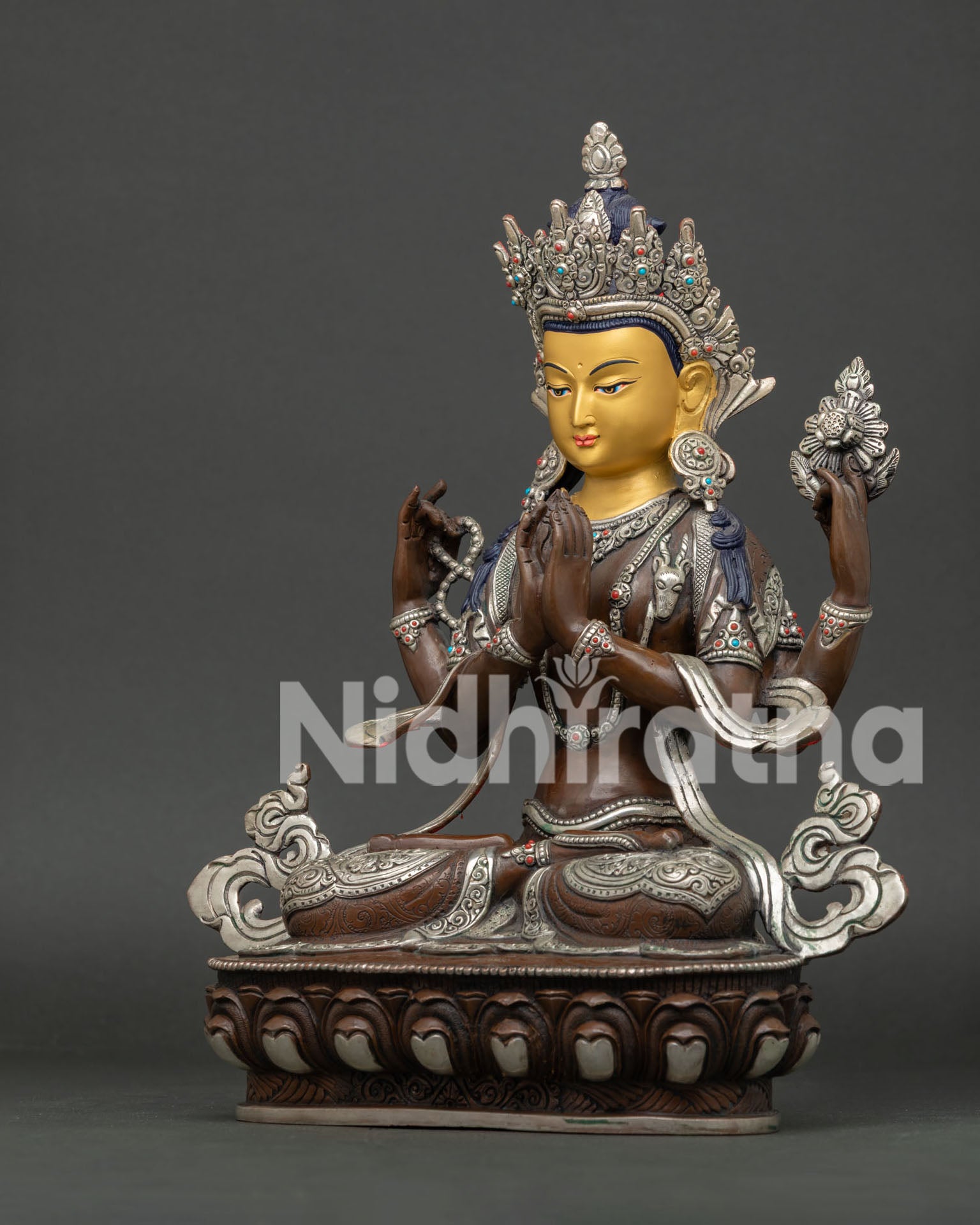 Side view of Chenrezig copper statue with oxidized silver-plated finish, lotus throne and silk scarf.