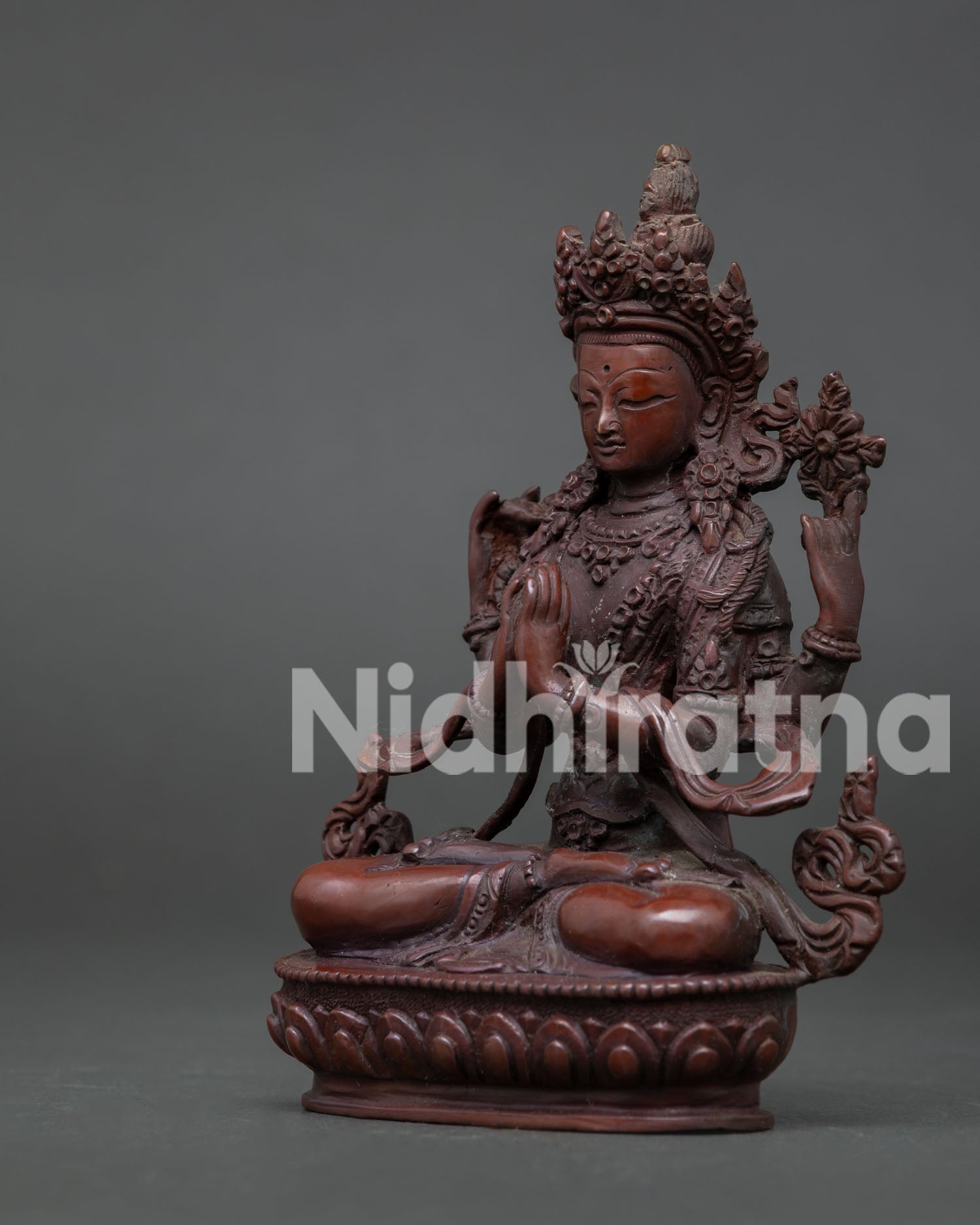 Side View of Chenrezig Statue with Blooming Lotus Flower and Flowing Silk Scarf.