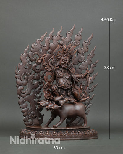 Side view of Dorje Gotrab statue riding buffalo surrounded by fire halo showing premium copper detailing oxidized texture
