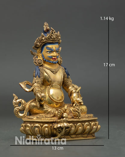 Side view of Dzambhala statue with copper body, gold detailing, lotus seat, and semi precious stones.