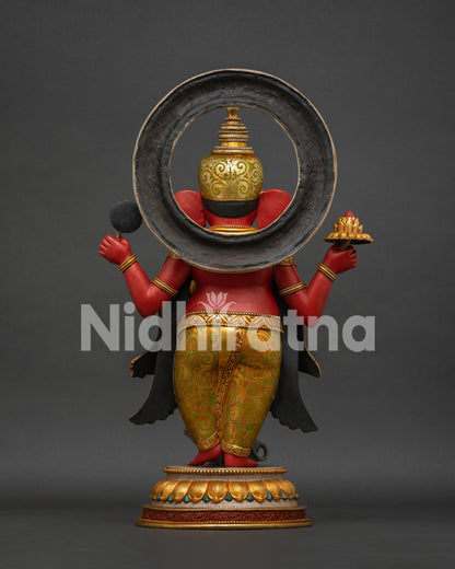 Side view of four-armed Ganesha copper statue with golden halo and lotus base
