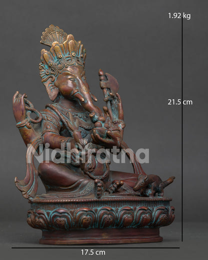 Side view of four armed Lord Ganesh statue seated on a lotus pedestal