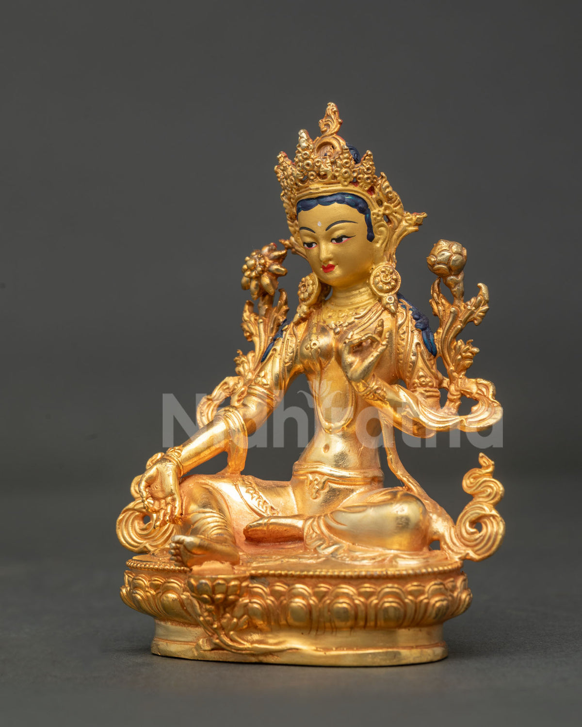 Side view of gold fire gilded Green Tara statue with celestial robes blooming lotus and detailed ornaments.