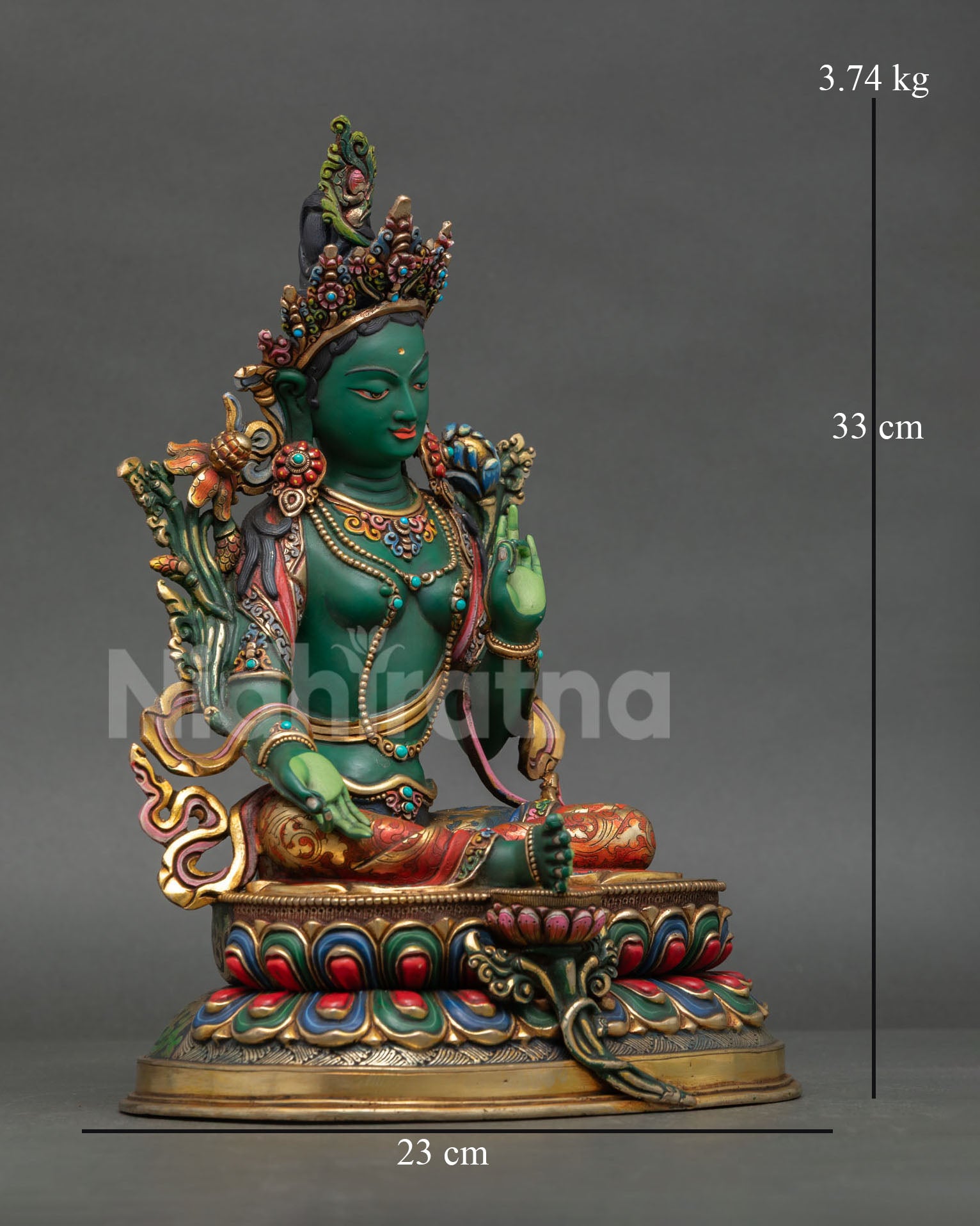 Side view of Green Tara sculpture in Lalitasana posture holding blue lotus flower and radiating protection and compassion.