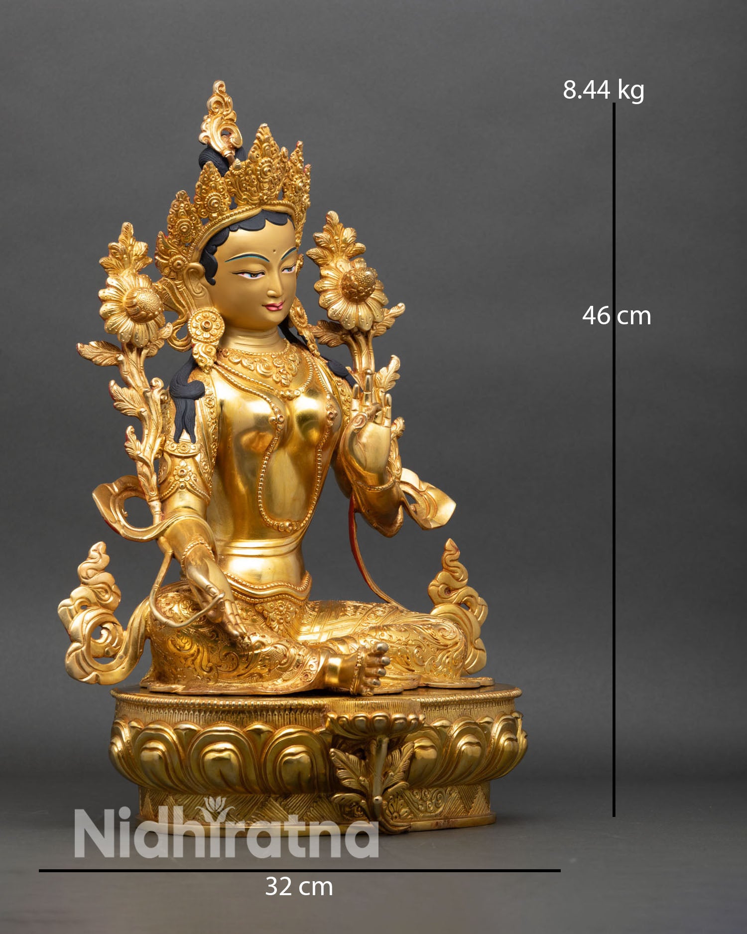Side view of Green Tara statue right leg extended resting on lotus flower